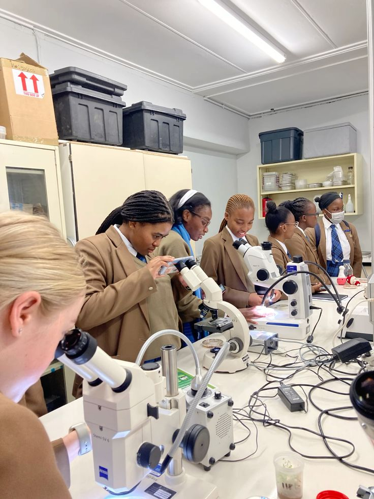 Students learning laboratory techniques with microscopes